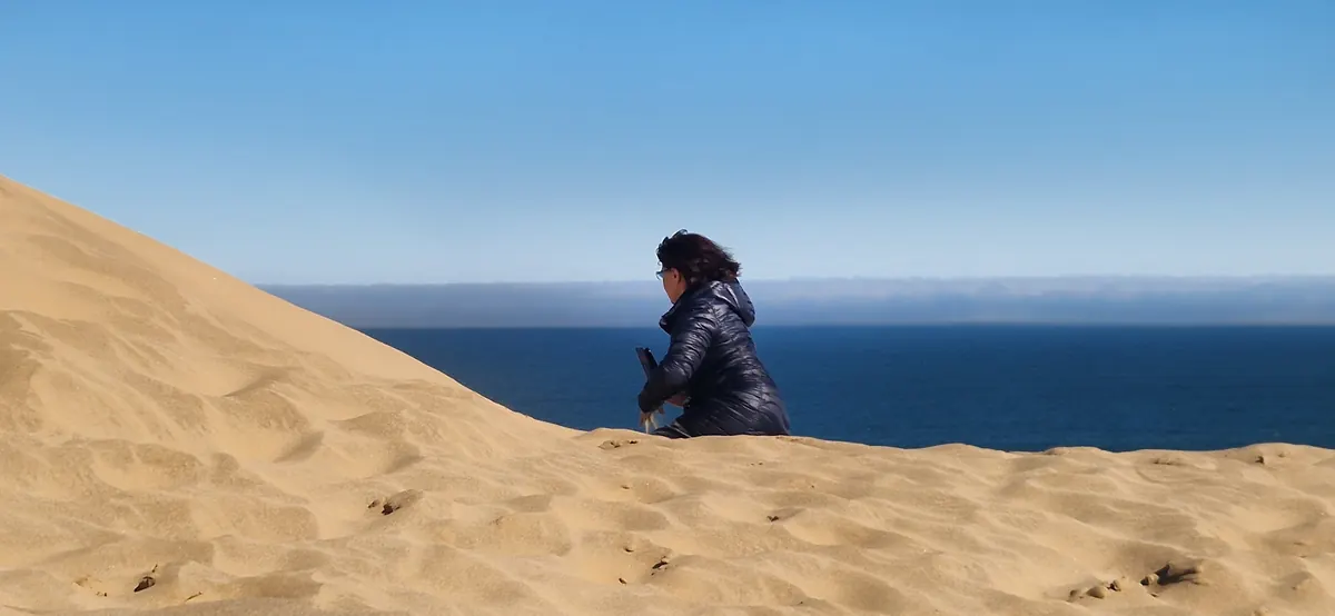 Guest on a dune overlooking the Atlantic at Sandwich Harbour